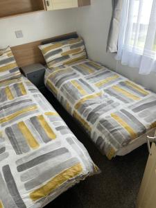 two beds sitting next to each other in a bedroom at 3-Bed homely modern caravan in Clacton-on-Sea in Clacton-on-Sea
