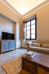 ein Wohnzimmer mit einem Sofa und einem TV in der Unterkunft Tuscan Palace - Venturi in Montepulciano