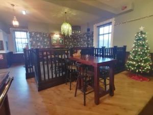 uma sala de jantar com uma árvore de Natal e uma mesa em The Waterford Arms em Hartley
