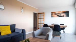 ein Wohnzimmer mit einem Sofa und einem Tisch in der Unterkunft Le Provençal - Vue paronomique sur Poitiers in Poitiers