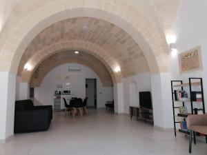 a living room with an archway with a table and chairs at Appartamento B&B VOLTE D'OGIVA in Altamura