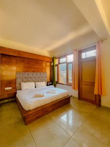 a bedroom with a bed and a large window at Pinewood by Offlimits Homes in Kasol