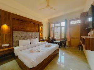 a bedroom with a large bed and a desk at Pinewood by Offlimits Homes in Kasol