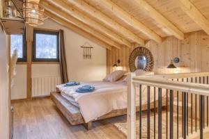 een slaapkamer met een bed in een kamer met houten wanden bij chalet Louis situé 25 km Chamonix in Saint-Gervais-les-Bains