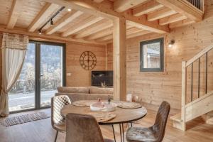 - un salon avec une table, des chaises et un canapé dans l'établissement chalet Louis situé 25 km Chamonix, à Saint-Gervais-les-Bains