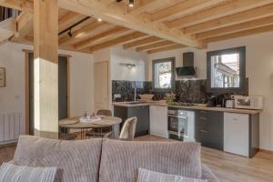 een woonkamer met een tafel en een keuken bij chalet Louis situé 25 km Chamonix in Saint-Gervais-les-Bains