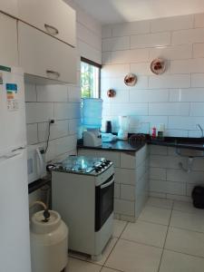 uma cozinha com um fogão e uma bancada em Flat em Porto de Galinhas "com varanda" em Porto de Galinhas