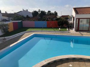 a swimming pool with a swing in a yard at CASA ROSA COSY PINK GUEST HOUSE in Torrão