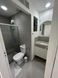 een badkamer met een douche, een toilet en een wastafel bij Loft Maria Helena I in Vila Velha