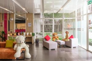 a lobby with a teddy bear sitting on a couch at The Idle Hotel and Residence - SHA Plus Certified in Pathum Thani
