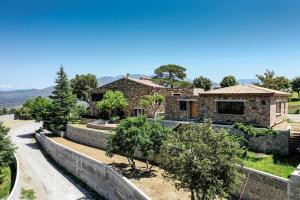 a stone house with a road in front of it at kyrn flor in Corte