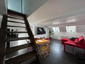 een woonkamer met een trap en een rode bank bij Appart stylé très spacieux Sedan 4E in Sedan