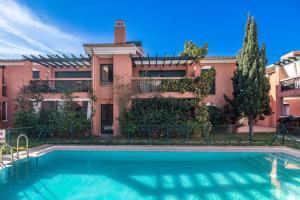 una casa con piscina delante de un edificio en Cabopino, cerca de todo, en Marbella