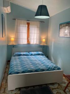 1 dormitorio con 1 cama con edredón azul en Etnachalet casa vacanze, en Belpasso