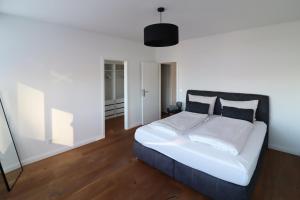 a bedroom with a white bed with a black headboard at Air Apartments 14 in Bremen