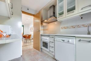 cocina con armarios blancos y comedor en Cabopino, cerca de todo, en Marbella