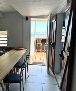 Habitación con mesa, sillas y vistas al océano. en Maeva Sunset en Saint-Leu