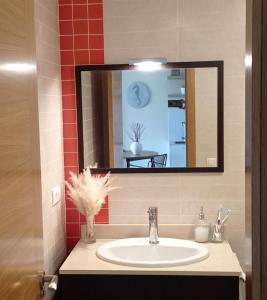 a bathroom with a sink and a mirror at Lanzada Apartments in Sanxenxo
