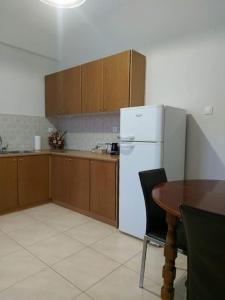 a kitchen with a table and a white refrigerator at CITY CENTER APARTMENT in Sparta