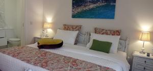 a bedroom with a large white bed with two night stands at A Casa da Ti Laura - AL in Aveiro