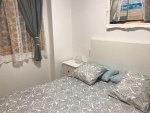 a bedroom with a bed with a pillow and a window at Estupendo Apartamento Mediterráneo in Faro de Cullera