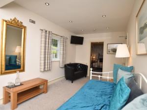 a living room with a blue bed and a mirror at 12 Bed in Capel Curig 93368 in Capel Curig