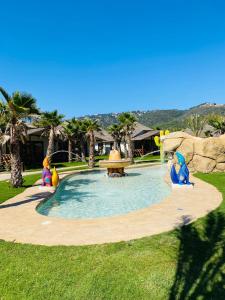 a swimming pool with two inflatables in a park at EL DELFÍN VERDE RESORTS - Platja d'Aro in Platja d'Aro