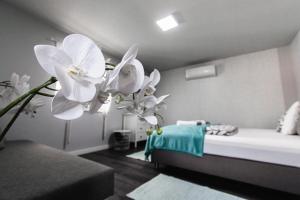 a room with a bed with white flowers in it at Sunny Garden Apartment in Bogács