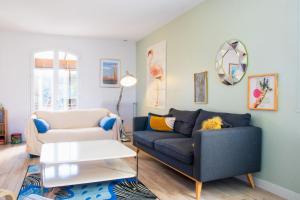 sala de estar con sofá y silla en La Pergola - Superbe maison au Futuroscope !, en Jaunay-Clan