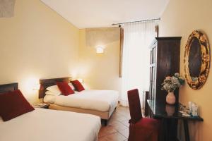 a hotel room with two beds and a mirror at Hotel Galileo in Florence