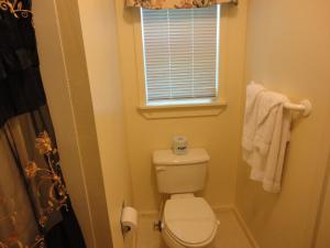 a small bathroom with a toilet and a window at Theater Motel in Westfield