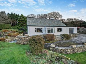 a white house with a stone wall at 3 Bed in Coniston 93329 in Torver