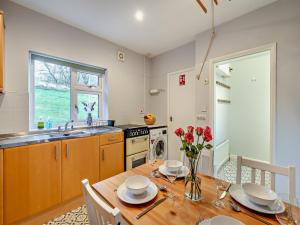 a kitchen with a wooden table with a vase of flowers at 3 Bed in Coniston 93329 in Torver