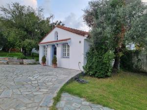 a small white house with a stone driveway at VILLA TELLINA in Skiathos Town