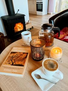 a table with a book and a cup of coffee at Klidná lokalita Na kraji lesa, celý dům s úschovnu kol in Nová Bystřice