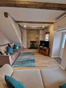 a living room with a couch and a fireplace at Riverbank Cottage, Dog Friendly. Swansea, Llanelli in Hendy