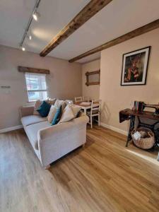 a living room with a couch and a table at Riverbank Cottage, Dog Friendly. Swansea, Llanelli in Hendy