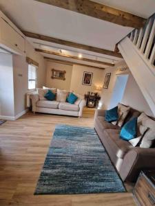 a living room with two couches and a rug at Riverbank Cottage, Dog Friendly. Swansea, Llanelli in Hendy