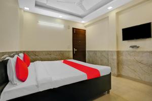 a bedroom with a bed with a tv on the wall at Flagship Welcome Hotel Near Dlf Avenue Saket in New Delhi