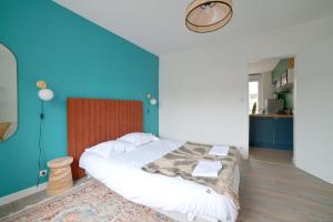 - une chambre avec un grand lit et un mur bleu dans l'établissement Le Relais Poitevin - Grand T3 proche gare, à Poitiers
