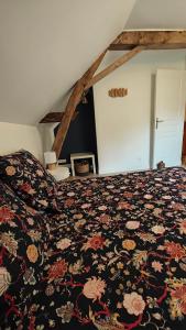 a bedroom with a bed with a floral bedspread at Le Petit Prieuré Langeais in Langeais