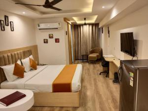 a hotel room with a bed and a desk and a television at The sky luxury home stay in Jaipur