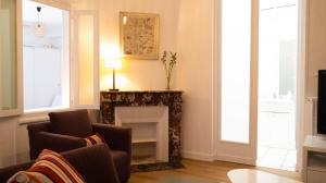 sala de estar con chimenea y 2 sillas en Le Puit de Lumière - Comfortable T3 in Poitiers!, en Poitiers