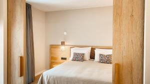 a bedroom with a bed with white sheets and pillows at htop Amatista #htopBliss in Lloret de Mar +37 photos