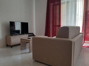 a living room with a couch and a television at Xlendi Home in Xlendi