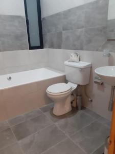 a bathroom with a toilet and a tub and a sink at Xlendi Home in Xlendi