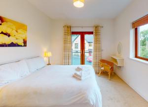 Un dormitorio con una gran cama blanca y una ventana en Lakeside HH No 30 - 2 Bed, en Killaloe