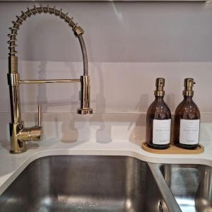 two bottles of wine sitting on a kitchen sink at Home at Highgrove - Private Garden & Parking in Reading
