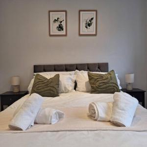 a large white bed with three pillows on it at Home at Highgrove - Private Garden & Parking in Reading