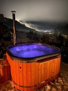 a large wooden hot tub with a view of a mountain at Chalet Black Deer in Mýto pod Ďumbierom